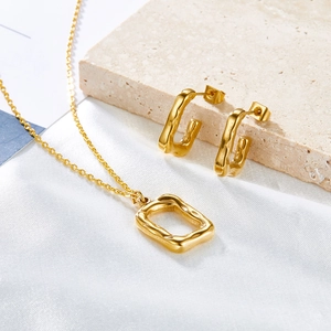 Elegant gold-tone geometric jewelry set with molten textured rectangular pendants on silk