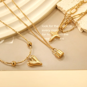 Gold stainless steel bracelet with heart, lock, and star charms on a textured chain