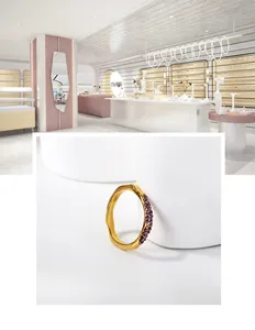Détail de la bague vague dorée sertie de deux rangées de cristaux violets et zircons