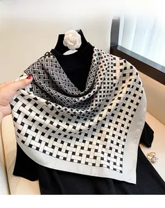 Detail view of black and white geometric woven pattern scarf on black fabric