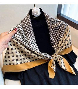 Detail of geometric pattern silk scarf with elegant cream, brown and yellow borders