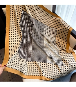 Detail of geometric pattern twill silk scarf with bold yellow border on chair