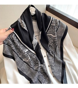 Detailed view of paisley and checkered printed silk scarf draped on white shirt