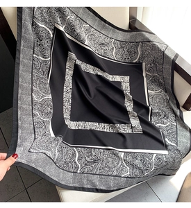 Macro shot of paisley and geometric pattern details on silk-like black white square scarf