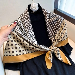 Silky geometric print square scarf in ginger and coffee tones on a black sweater