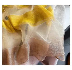 Detailed macro view of silk blend scarf fabric with metallic gold stripes and hemmed edges