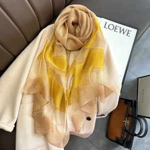 Detailed macro view of the silky geometric striped scarf paired with an elegant wool coat