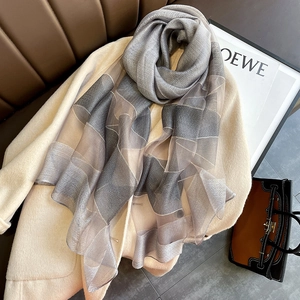 Detail of silk-blend gray geometric colorblock scarf draped on a beige wool coat