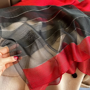Detail of color-block silk blend scarf showing transparent texture and silver stripes