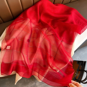 Detail of red silk blend scarf with silver Lurex stripes and woven brand logo tag