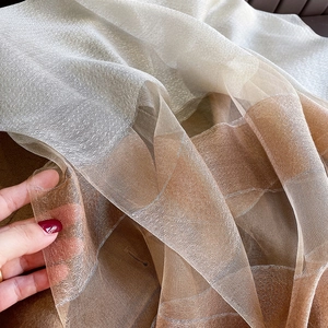 Macro shot of lightweight silk blend scarf showing sheer texture and gold gradient