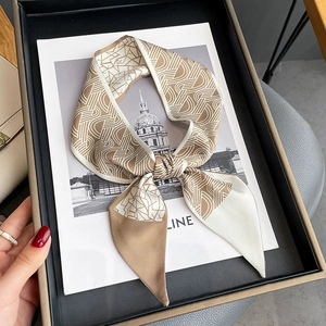 Élégant foulard en soie à motif géométrique beige et marron présenté dans un coffret cadeau