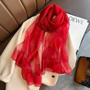 Red silk blend scarf with silver stripes draped over a stylish beige wool coat