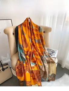 Détail d'une écharpe en soie style peinture à l'huile avec motifs de feuilles orange