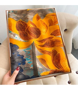 Détail d'une écharpe en soie style peinture avec lotus jaune sur plateau doré