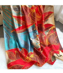 Détail d'un foulard en soie à imprimé lotus rouge avec bordures dorées et couture fine