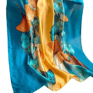 Elegant silk scarf with ginkgo leaf print in deep blue and gold on white background