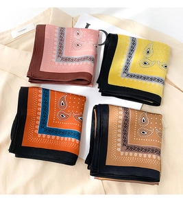 Detail of four silk scarves with paisley patterns in pink, yellow, and orange satin