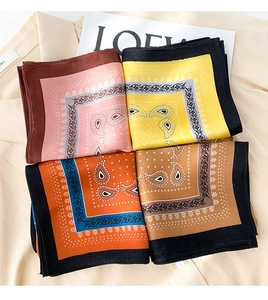 Flat lay of colorful silk square scarves with paisley patterns and satin texture