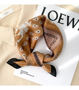 Detail of silk scarf with paisley and equestrian patterns on a white shirt