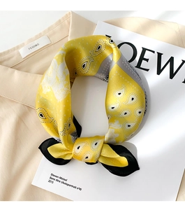 Detail of yellow paisley silk scarf tied neatly on a shirt for an elegant autumn look