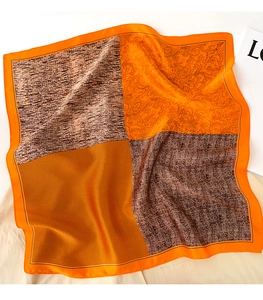 Détail d'un foulard en soie avec motifs floraux, grain de bois et texture marbrée