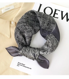 Détail d'un foulard en soie avec motifs pied-de-poule et géométriques sur une chemise