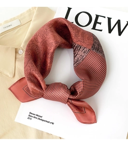 Détail du foulard en soie luxueux avec motifs paisley et pied-de-poule noué