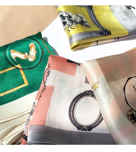 Close-up of silk scarves with retro art prints showing satin texture and rolled edges