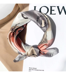 Close-up of silk scarf with vintage clock patterns and soft metallic luster textures