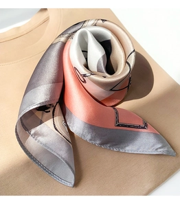 Detailed view of luxury silk scarf showing elegant geometric patterns and satin texture