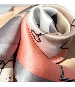 Macro shot of silk scarf showing glossy texture with coral and grey key pattern