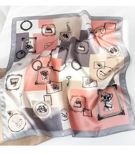 Detailed view of silk square scarf featuring retro fashion symbols and smooth satin texture
