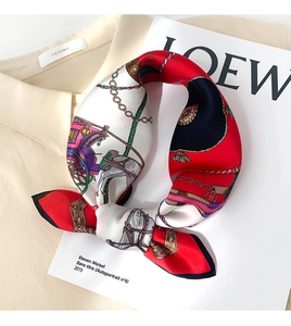 Close-up of silk scarf with vintage carriage and horse print tied in an elegant bow