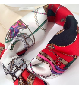 Detailed view of silk scarf with vintage carriage print and luxurious glossy texture