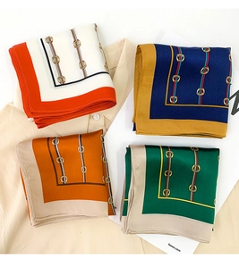 Flat lay of four silk square scarves featuring vintage chain horsebit patterns