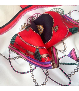 Close-up of silk scarf showing vintage carriage wheel and gold chain pattern texture