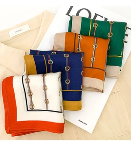 Detailed view of silk square scarves featuring equestrian horsebit patterns in vibrant colors
