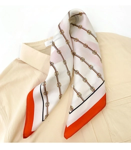 Detailed view of elegant silk square scarf with chain pattern tied around a shirt collar