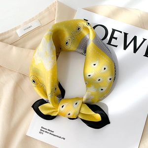 Yellow silk paisley square scarf with contrast black border styled on a neutral background