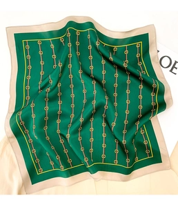 Detail of silk square scarf showing vintage gold chain pattern on deep green fabric