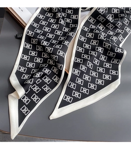 Détail d'un foulard en soie twilly monogramme noir et blanc avec pointes et étiquette