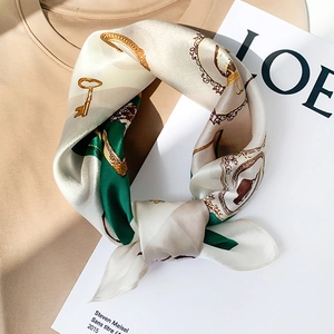 European vintage emerald silk square scarf with golden key pattern on a khaki shirt