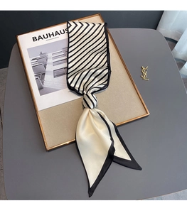 Detail shot of black and white striped twilly silk scarf on minimalist background