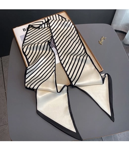 Detailed view of a black and white striped twilly scarf on a stylish background