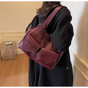 Detail der vintage weinroten Shopper-Tasche aus strukturiertem Leder mit Fronttaschen