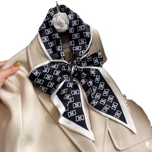 Élégant foulard en soie noir et blanc à motifs géométriques sur un blazer beige chic