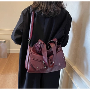 Detail der vintage burgunderroten Totebag mit weichem Leder und Metallnippen-Details