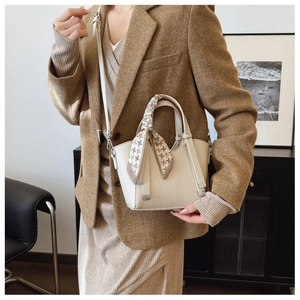Detail of white lychee leather bucket bag with houndstooth scarf and wave-cut edge