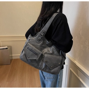 Detail der dunkelgrauen Retro-Tasche mit Cargotaschen und Vintage-Ledertextur